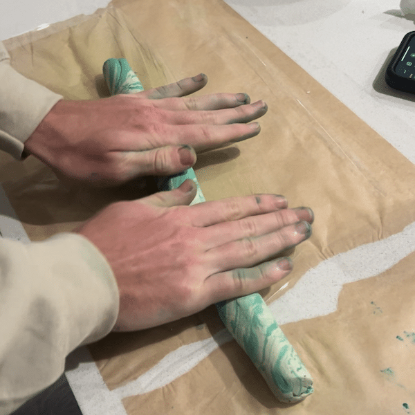 Man rolling out marbled clay on a long distance date