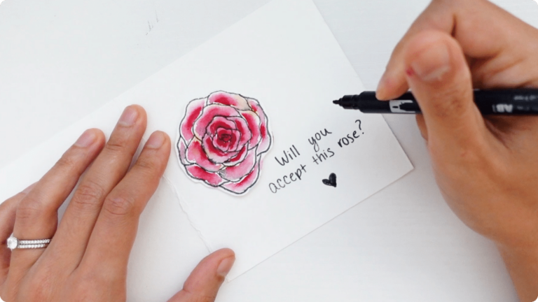 Hands making a love note for long distance couples with watercolors